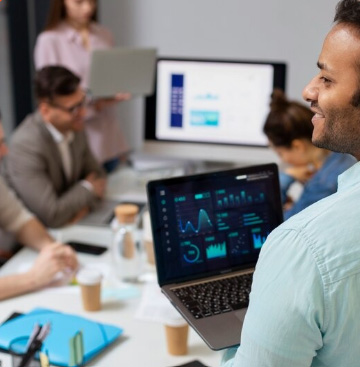 Equipe em reunião analisando dados em notebook
